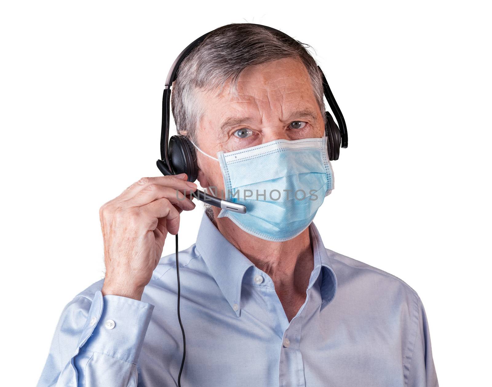 Senior caucasian man wearing facemask using headset to talk to customers or team during coronavirus epidemic. Isolated against white background
