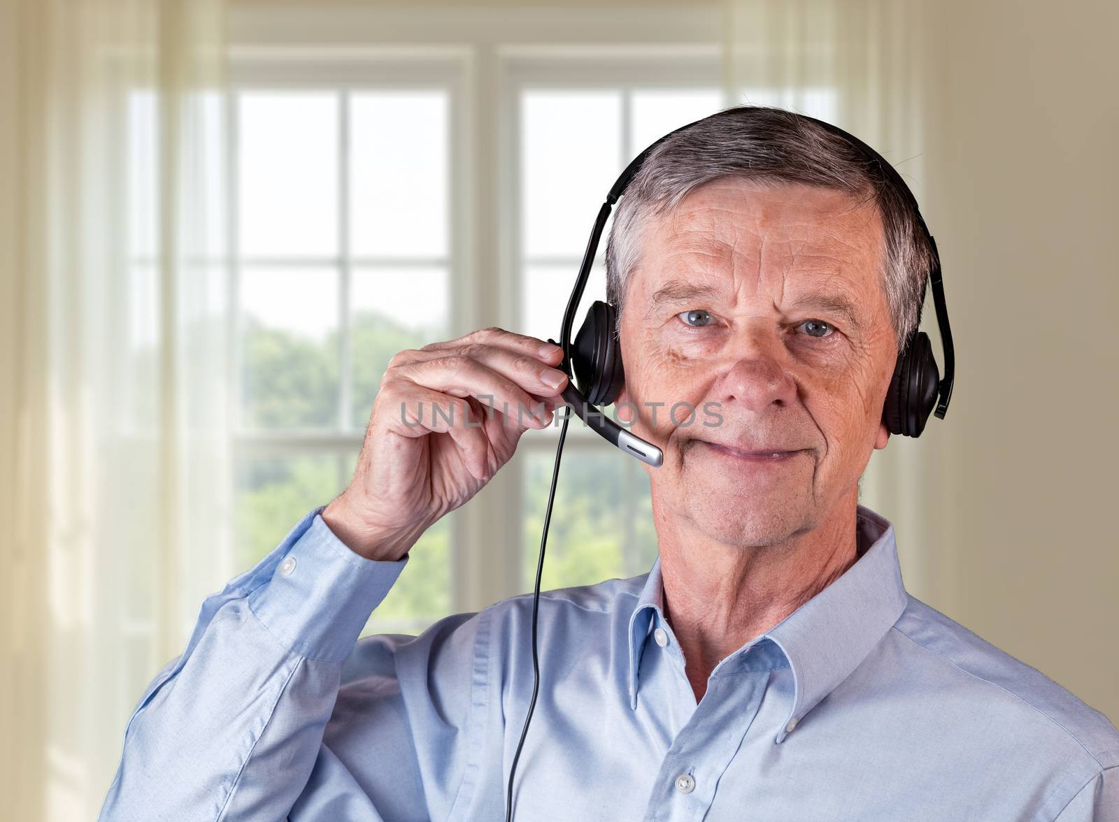 Senior man using headset to communicate with team or customers by steheap