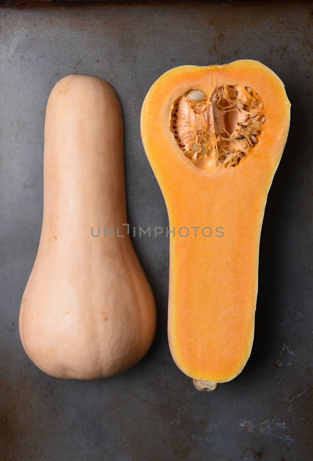 High angle view of a Butternut Squash cut in half on a metal baking sheet.