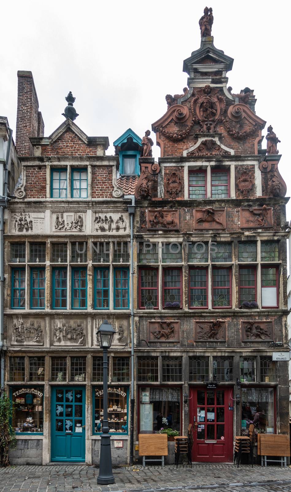 Ghent, Belgium - September 23, 2018: Seven Works of Mercy house and the Flutist house in Kraanlei are two medieval houses with fresco decorated facades. First is now candy store, second a Thai restaurant.