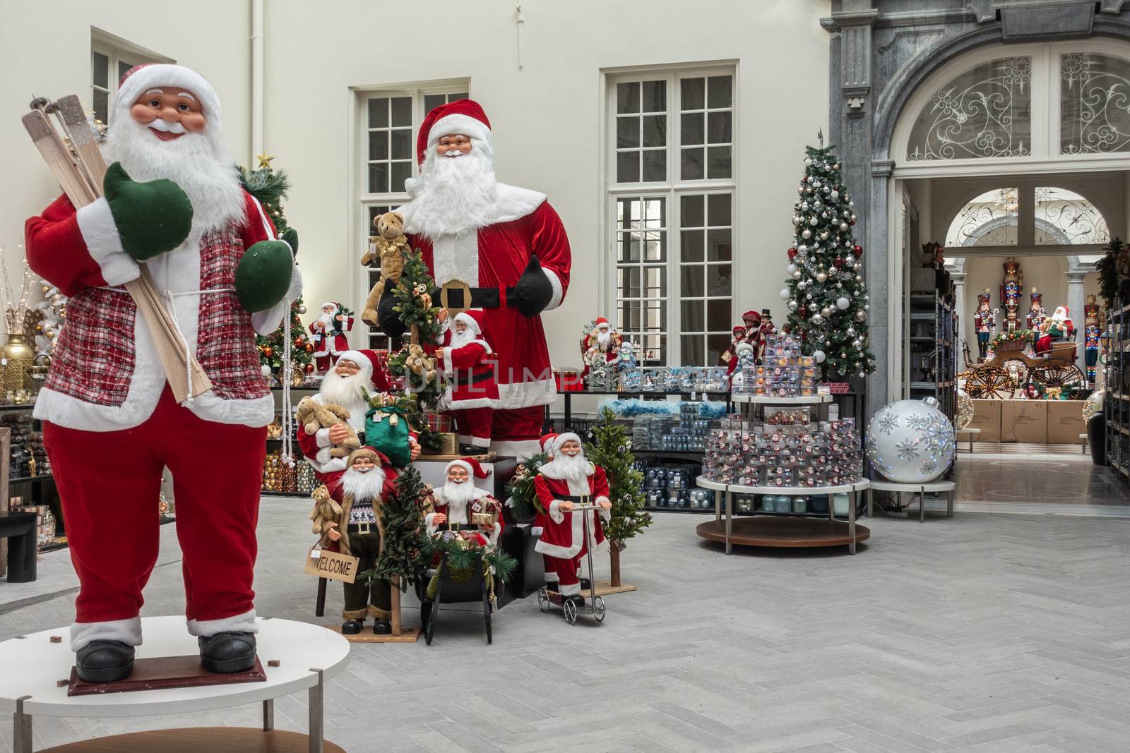 Antwerp, Belgium - September 24, 2018: Two tall Santa Claus mannequins surrounded by more smaller ones and Christmas gifts in store on Meir.
