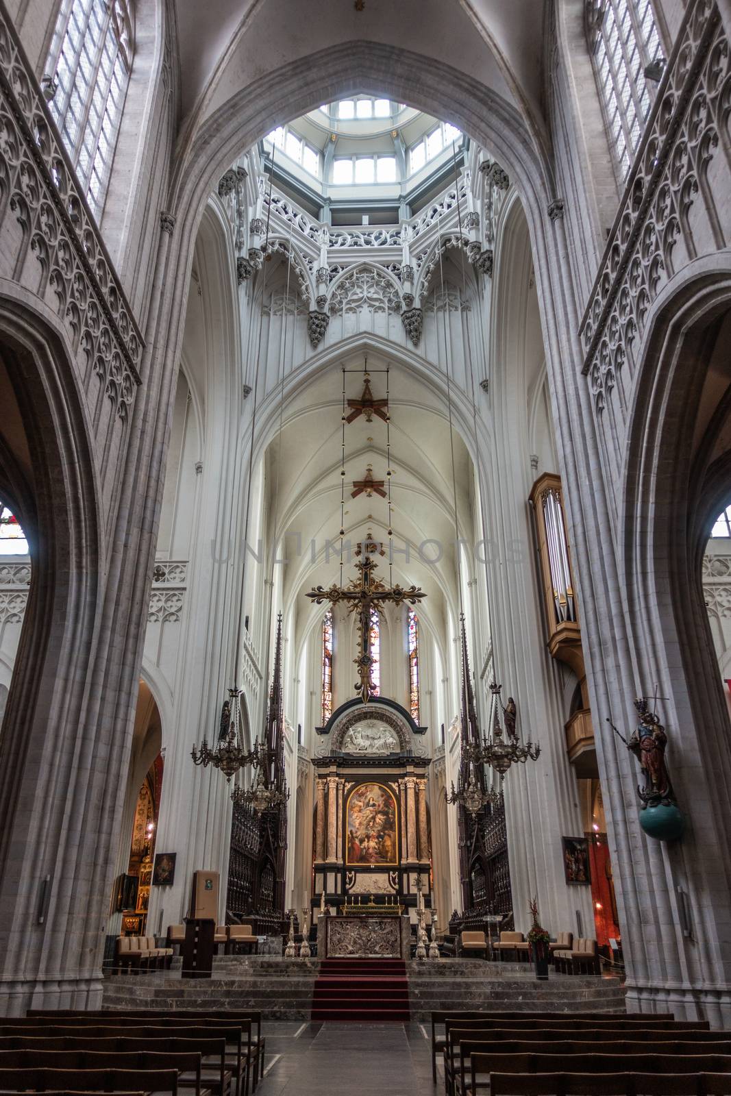 Antwerp, Belgium - September 24, 2018: Long shot on The Assumption of the Virgin Mary painting by Rubens above main altar in Onze-Lieve-Vrouw Cathedral of Our Lady. Pillars, arches, organ, benches.