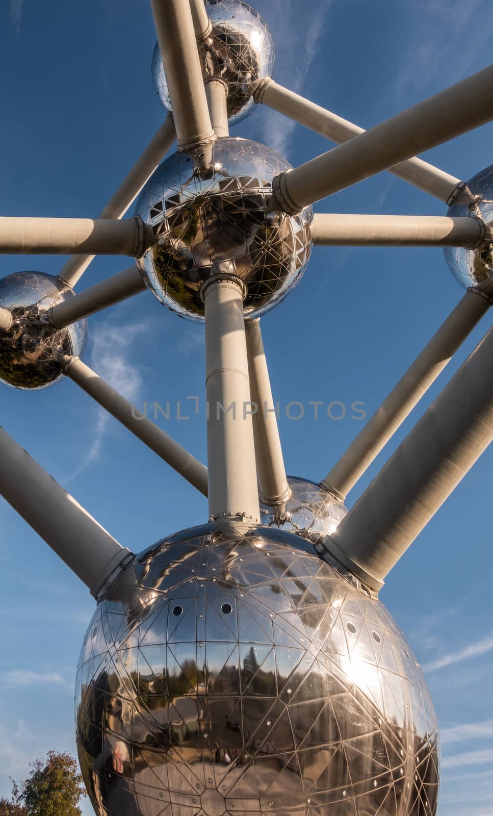 Brussels, Belgium - September 25, 2018: Six silver shining spheres of the voluminous Atomium monument and tubes against blue sky.