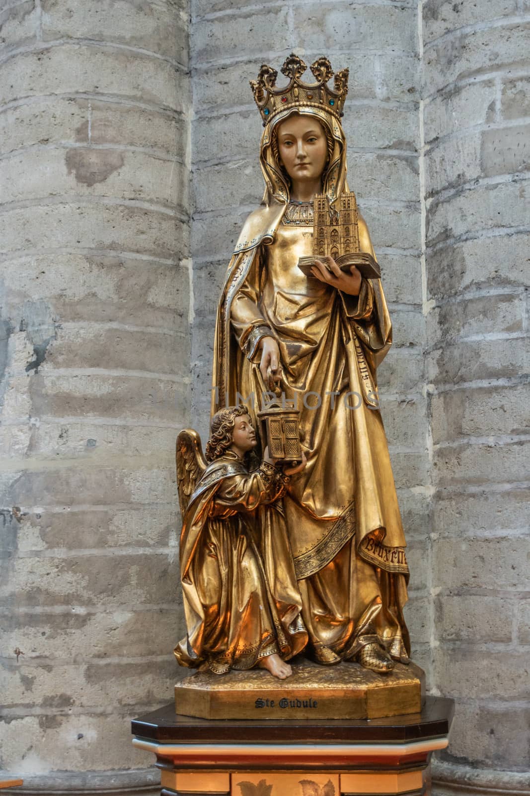 Brussels, Belgium - September 26, 2018: Closeup of Statue of Saint Gudula in Cathedral of Saint Michael and Saint Gudula against gray stone wall of pillar.