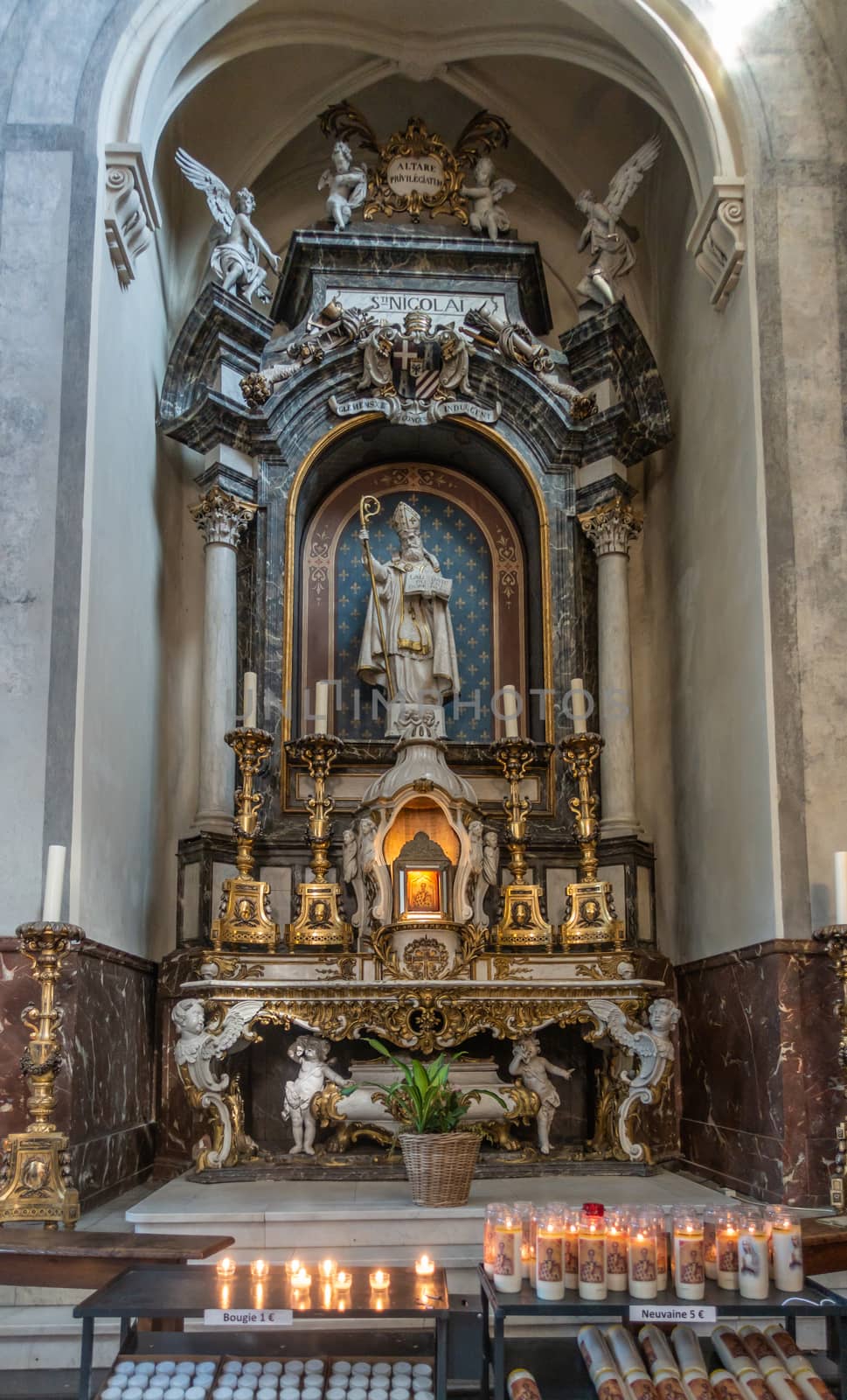 Brussels, Belgium - September 26, 2018: Inside Saint Nicolas Church. The saint has his own dedicated altar with plenty of angel statues, candles and golden decorations.