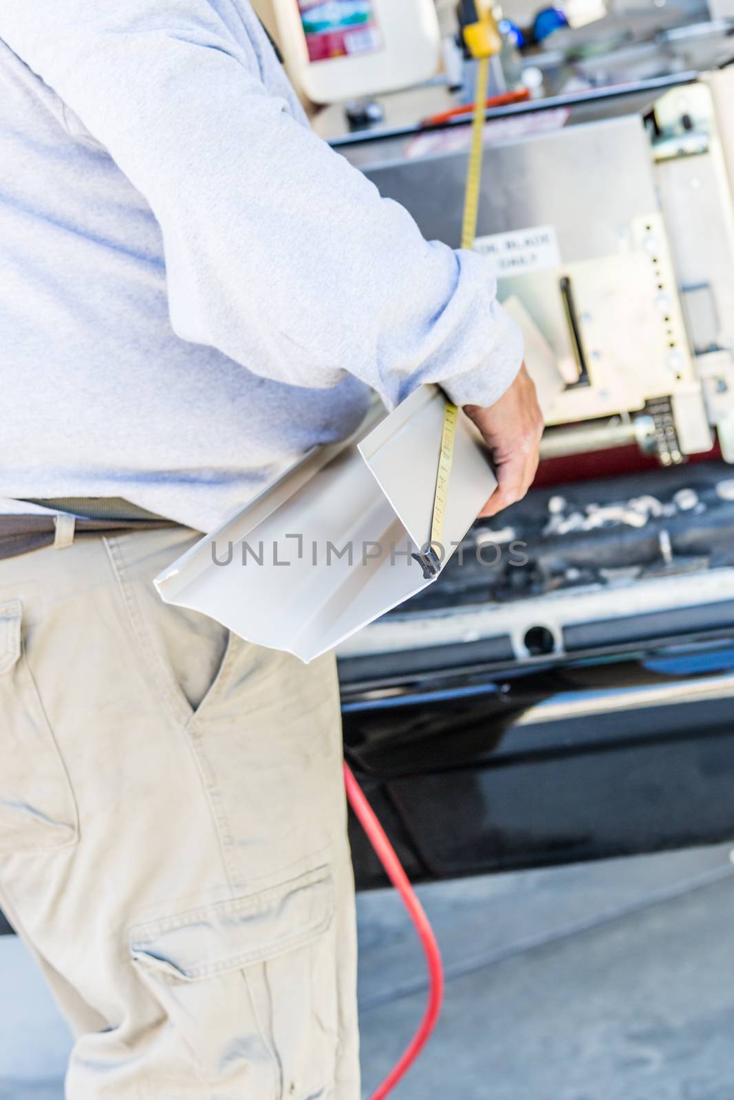 Worker Measuring Rain Gutter Processing Through Seamless Shaping Machine. by Feverpitched