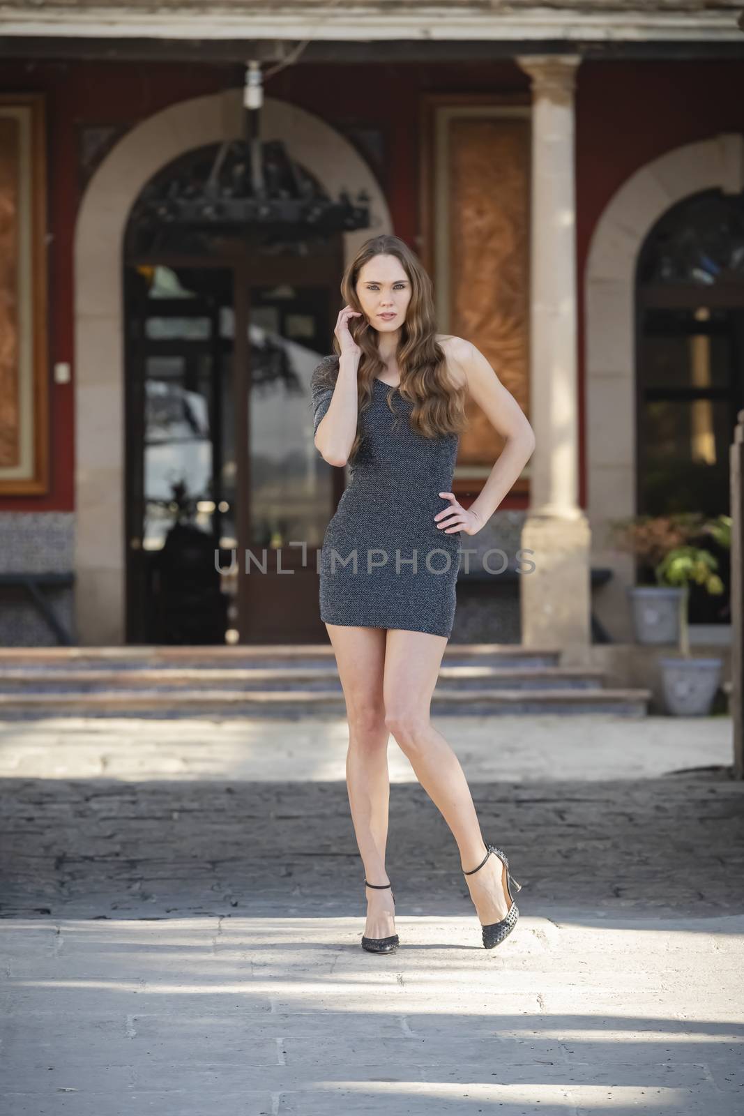 A gorgeous Hispanic Brunette model poses outdoors in home environment