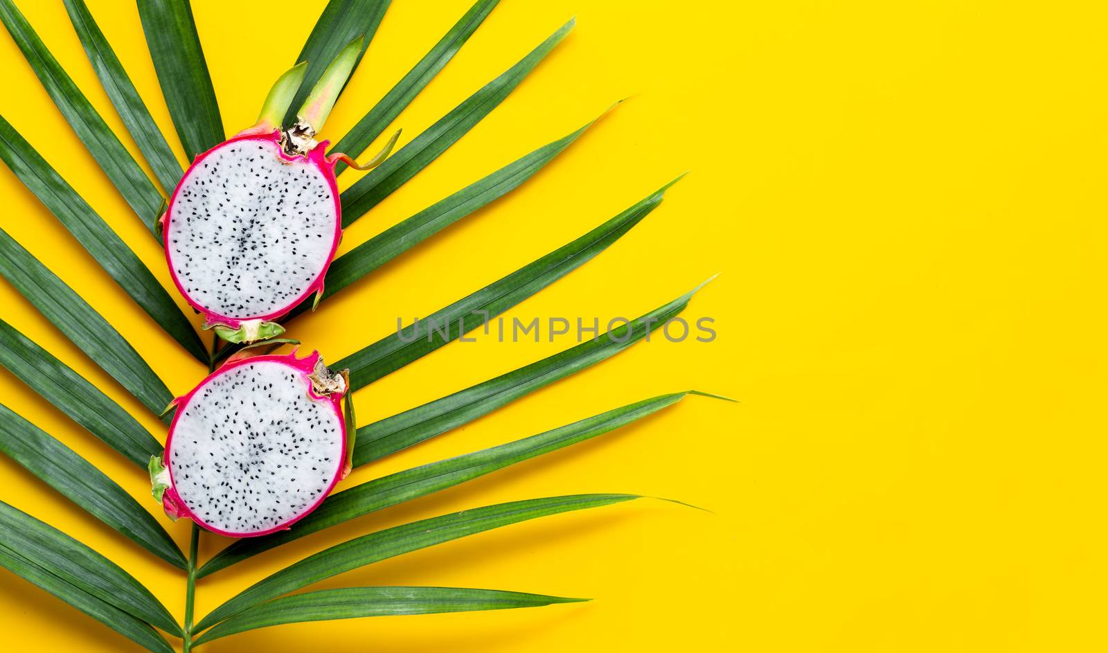 Ripe dragonfruit or pitahaya on tropical palm leaves. Top view