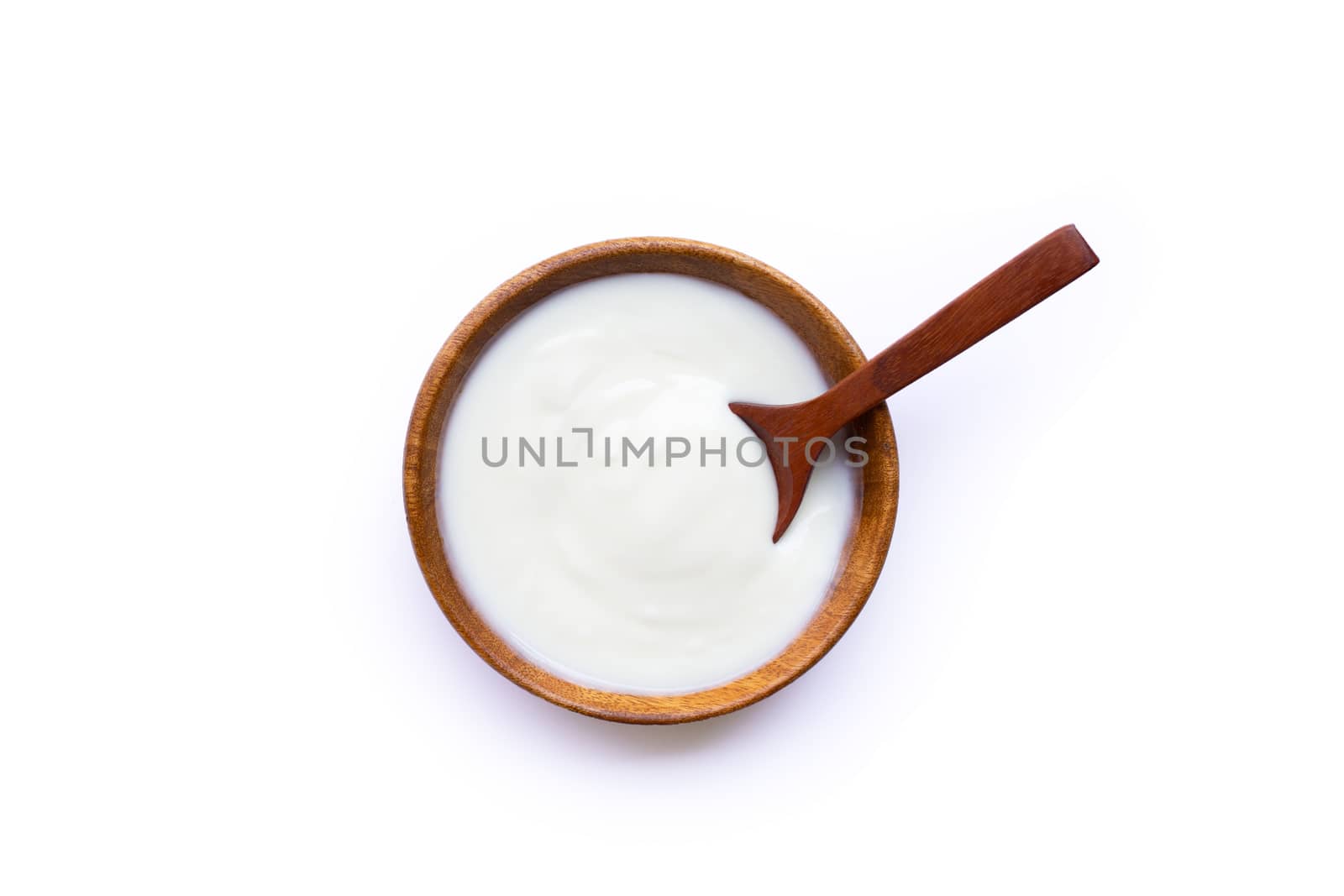 White yogurt in wooden bowl on white background. Top view