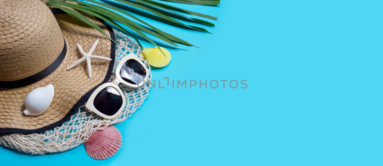 Summer hat with sunglasses on blue background. Enjoy holiday concept. Copy space