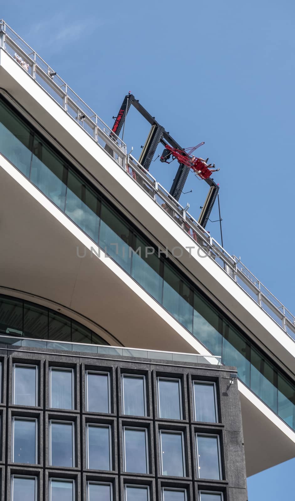 Amsterdam, the Netherlands - June 30, 2019: Closeup of daredevil swing instatllation on top of A’Dam lookout tower against blue sky.