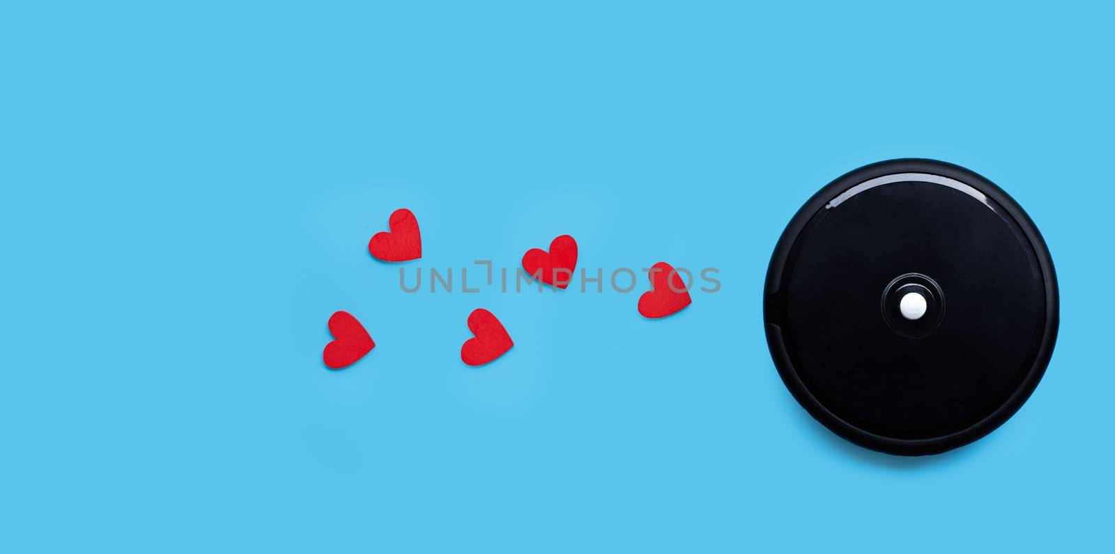 Robotic vacuum cleaner with red hearts on blue background.