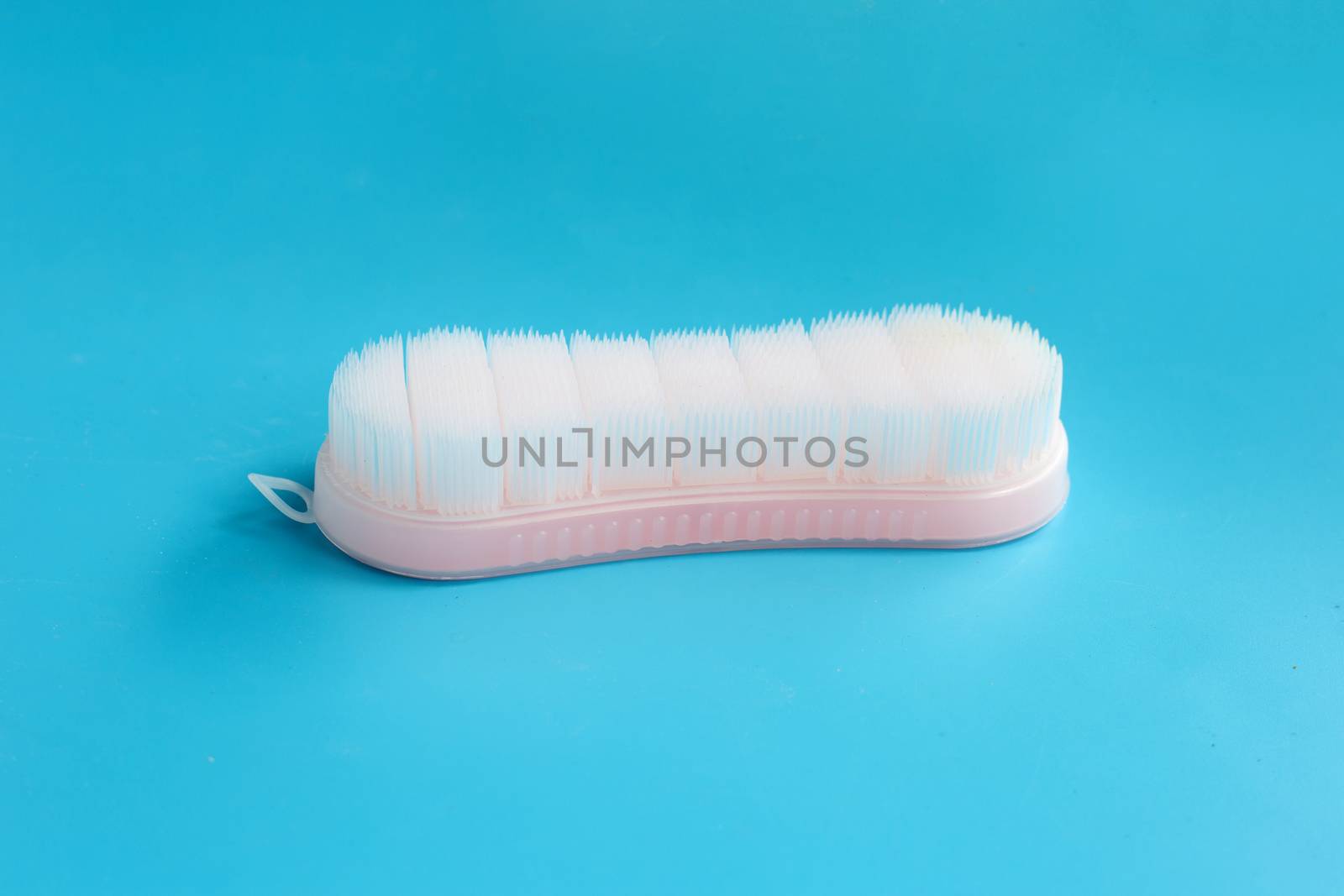 Brush for cleaning clothes on blue background.