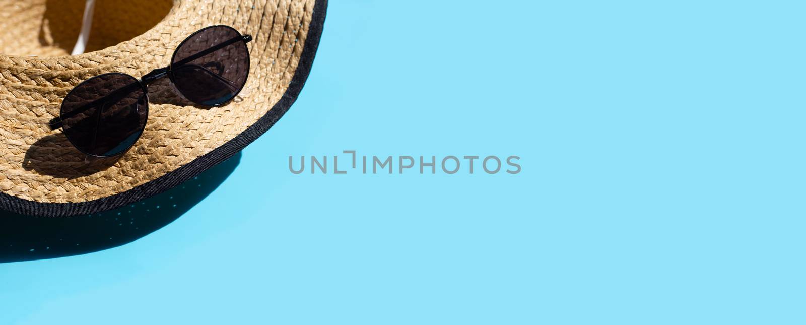 Hat with sunglasses on blue background. Enjoy summer holiday concept. Copy space