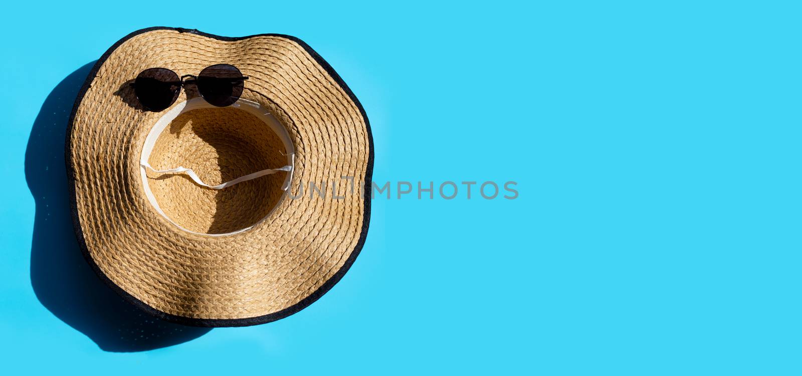 Hat and sunglasses on blue background. Enjoy summer holiday concept. Copy space