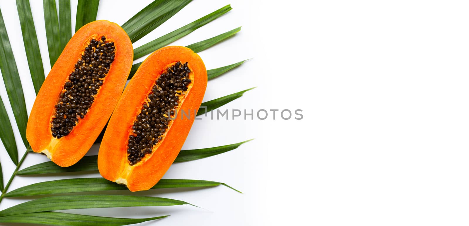 Sweet ripe papaya on tropical palm leaves. Top view with copy space