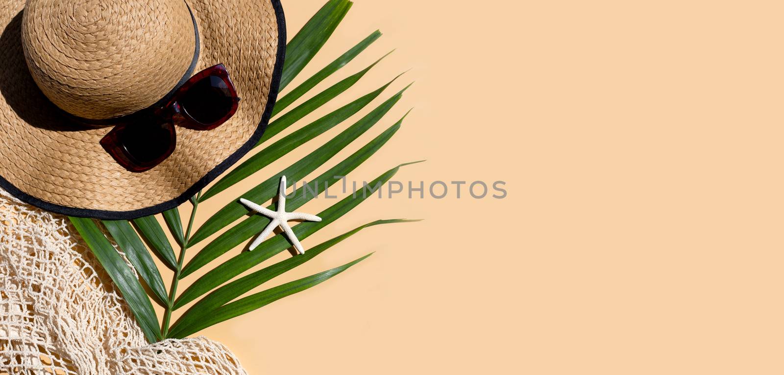 Summer hat with sunglasses on brown background. Enjoy holiday concept. Copy space
