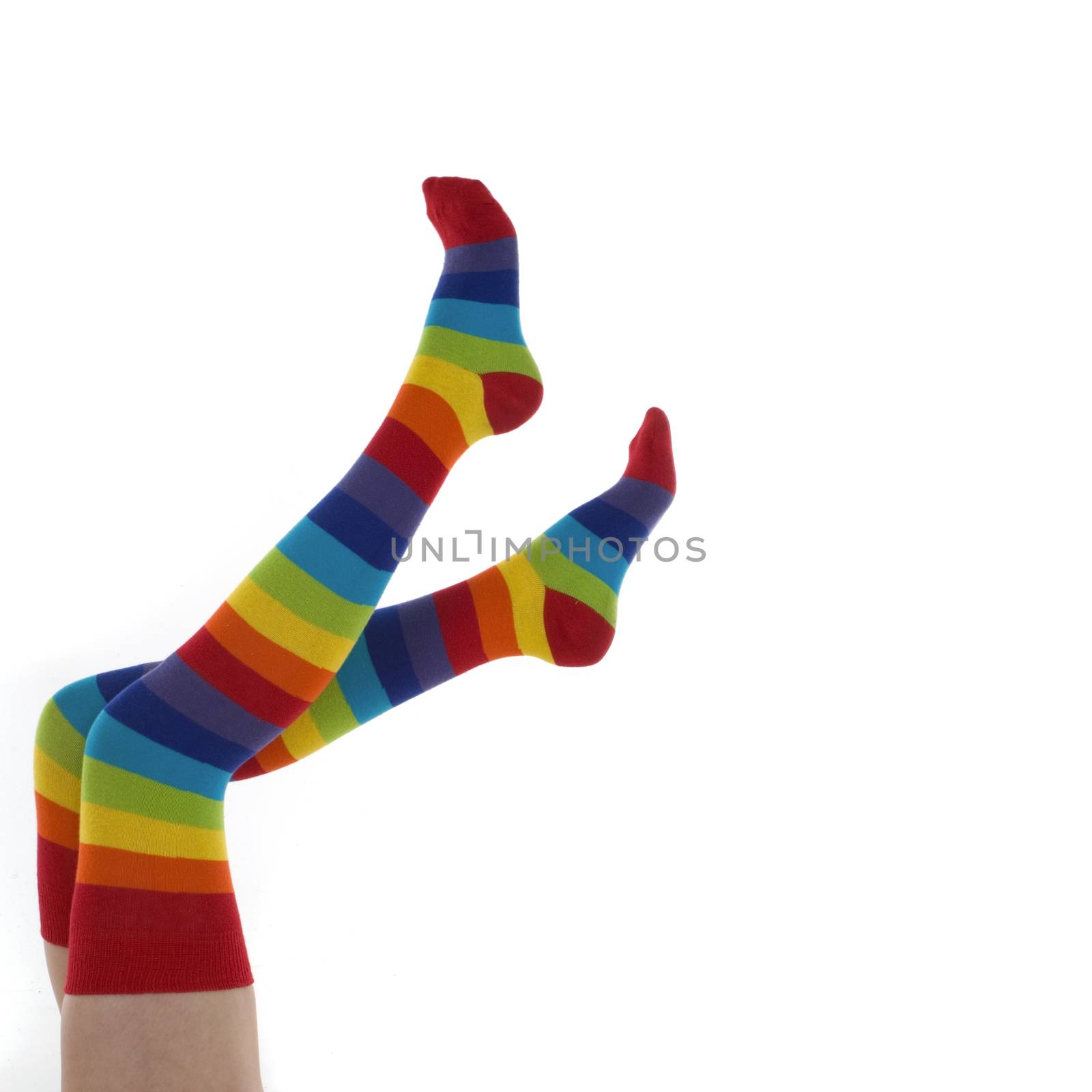 A pair of female legs clad in stripy rainbow socks