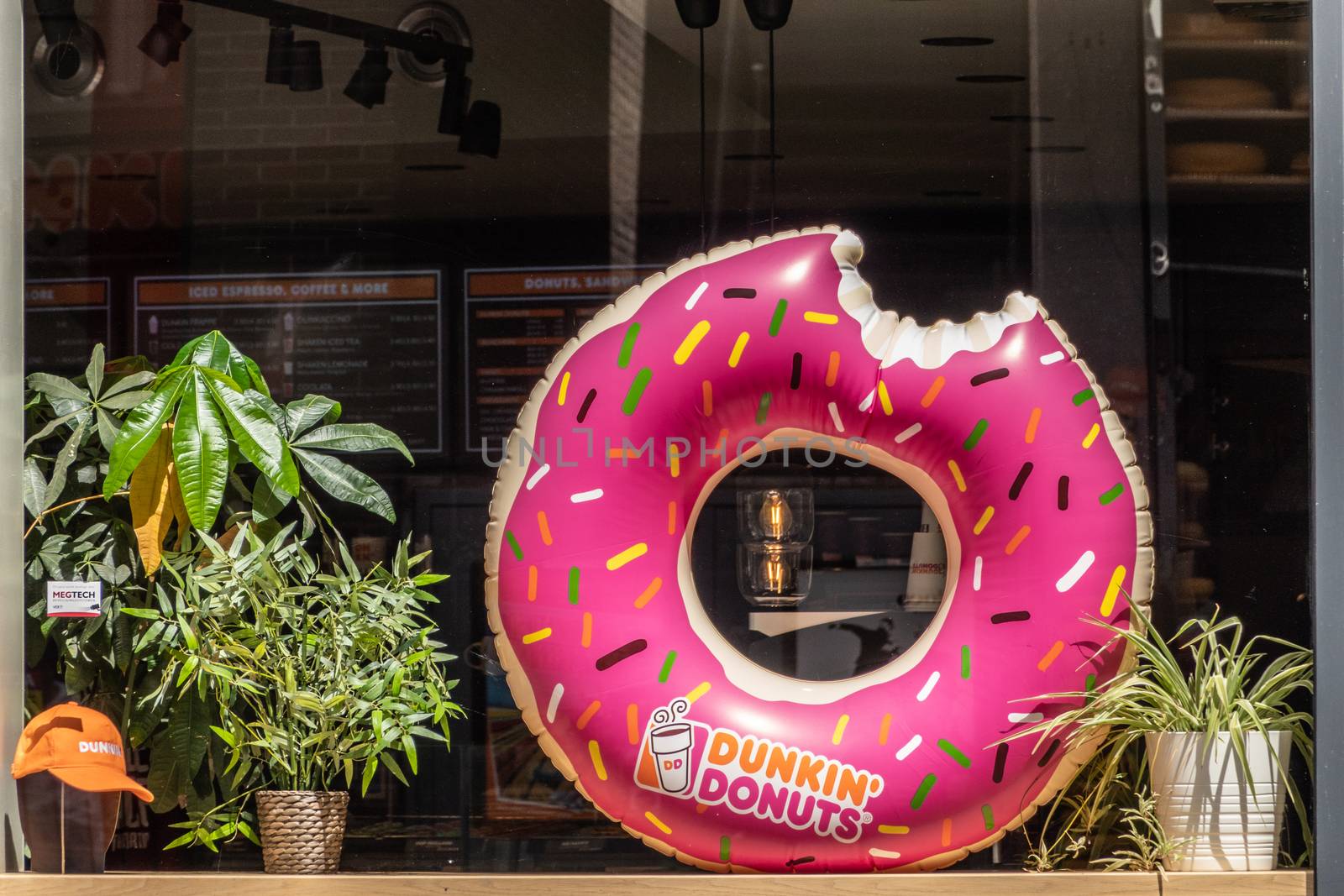 Amsterdam, the Netherlands - July 1, 2019: Giant blown-up image of pink Dunkin’Donuts image in window of shop with same name.