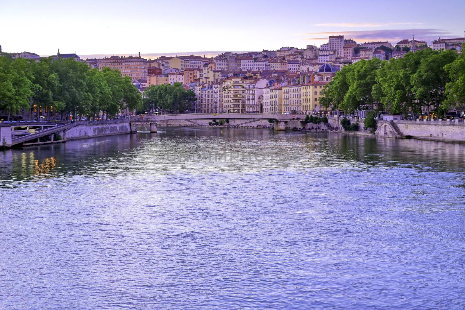 A view of Lyon, France along the Saône river at sunset.