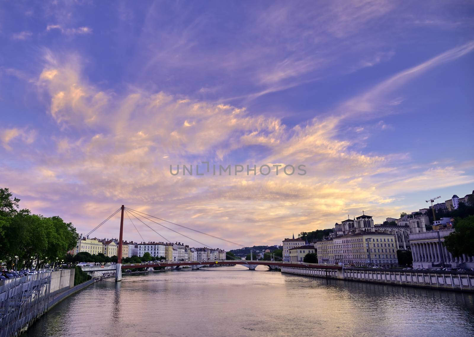 A view of Lyon, France along the Saône river at sunset.