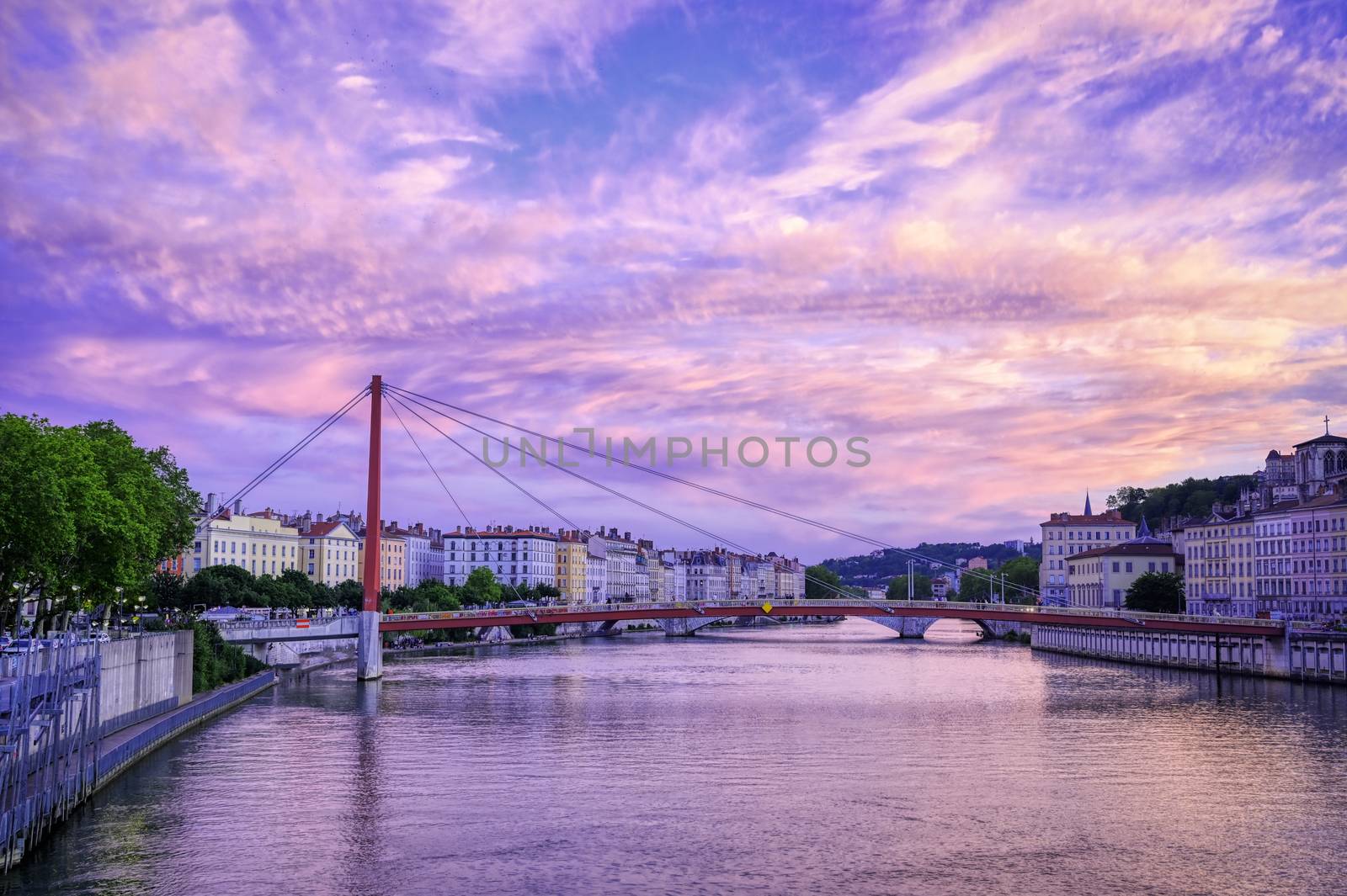 A view of Lyon, France along the Saône river at sunset.