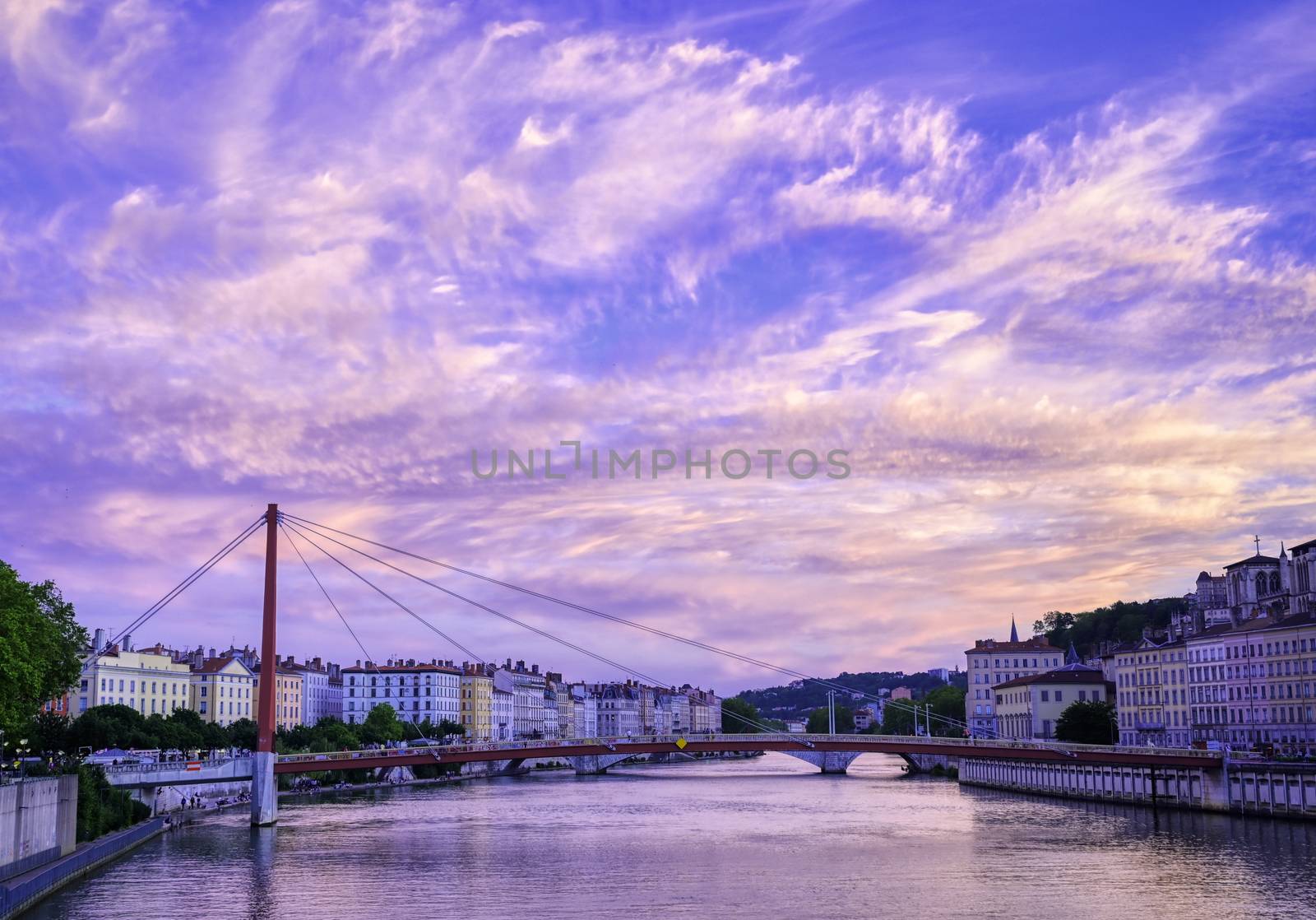 A view of Lyon, France along the Saône river at sunset.