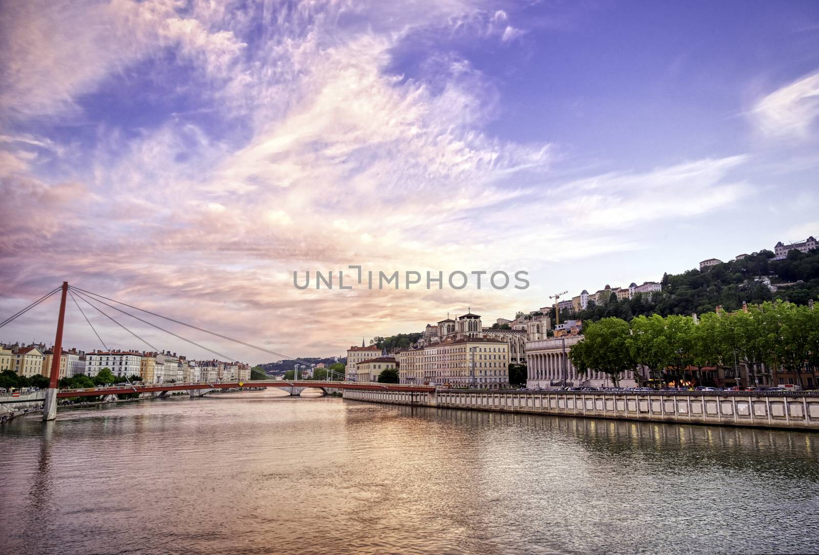 A view of Lyon, France along the Saône river at sunset.