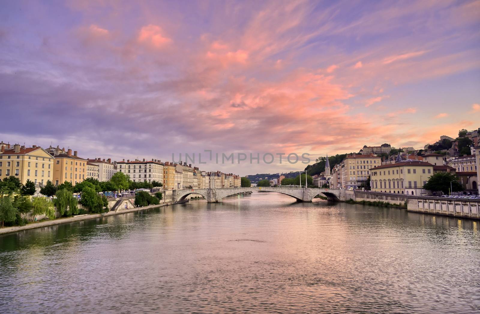 A view of Lyon, France along the Saône river at sunset.