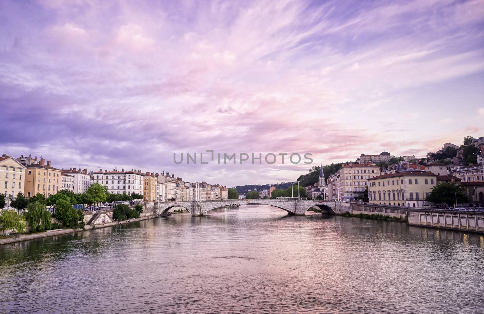 A view of Lyon, France along the Saône river at sunset.