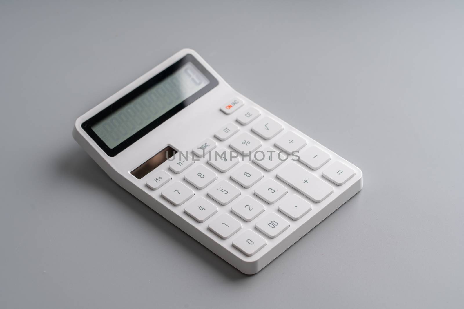 White calculator on grey background for education & business concept