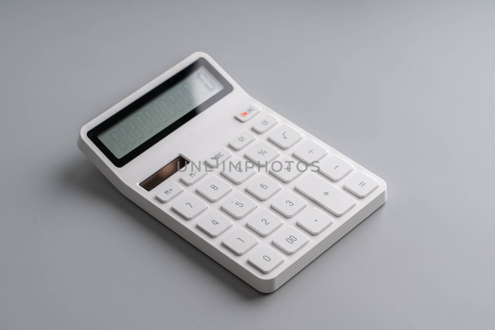 White calculator on grey background for education & business con by Alicephoto