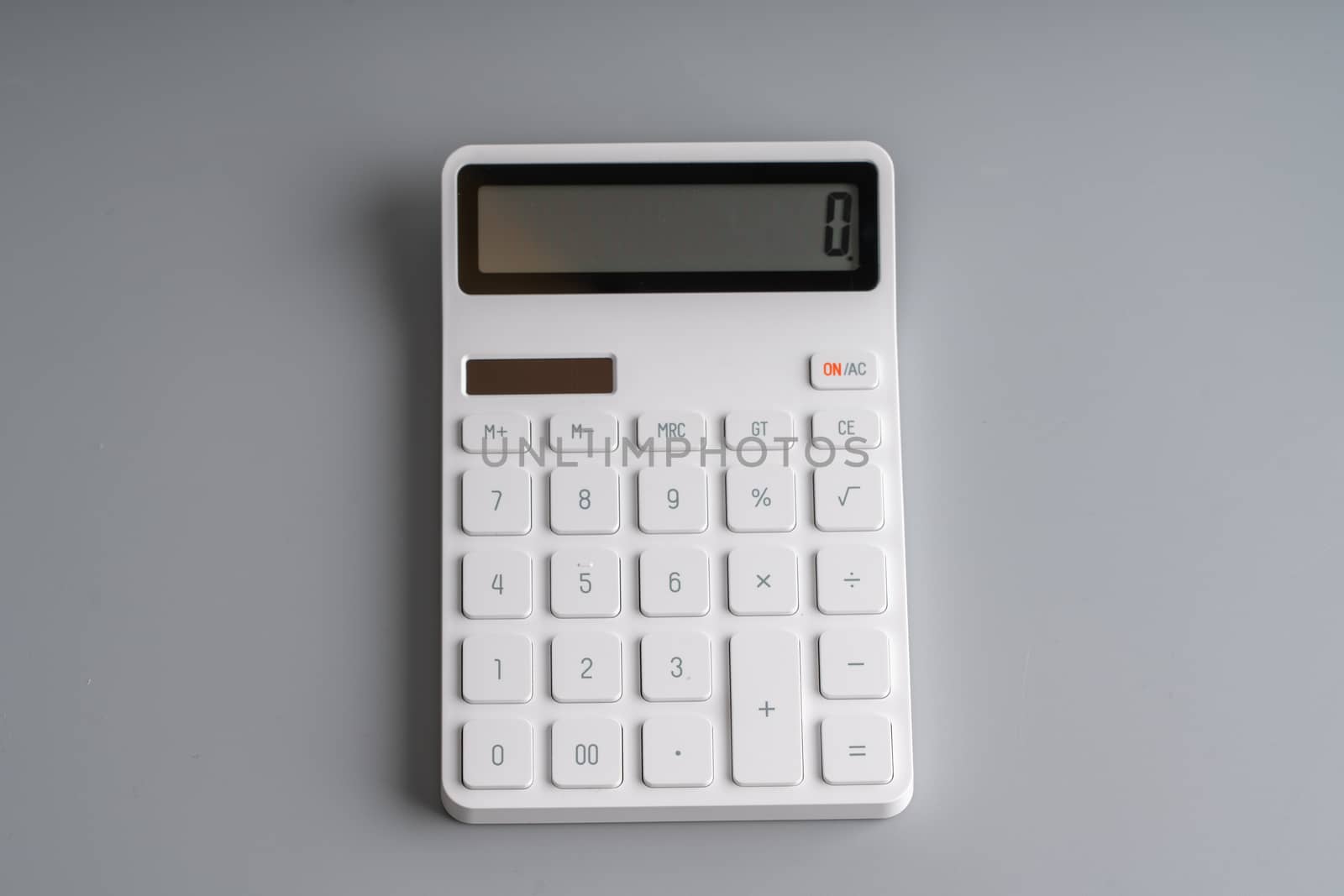 White calculator on grey background for education & business con by Alicephoto