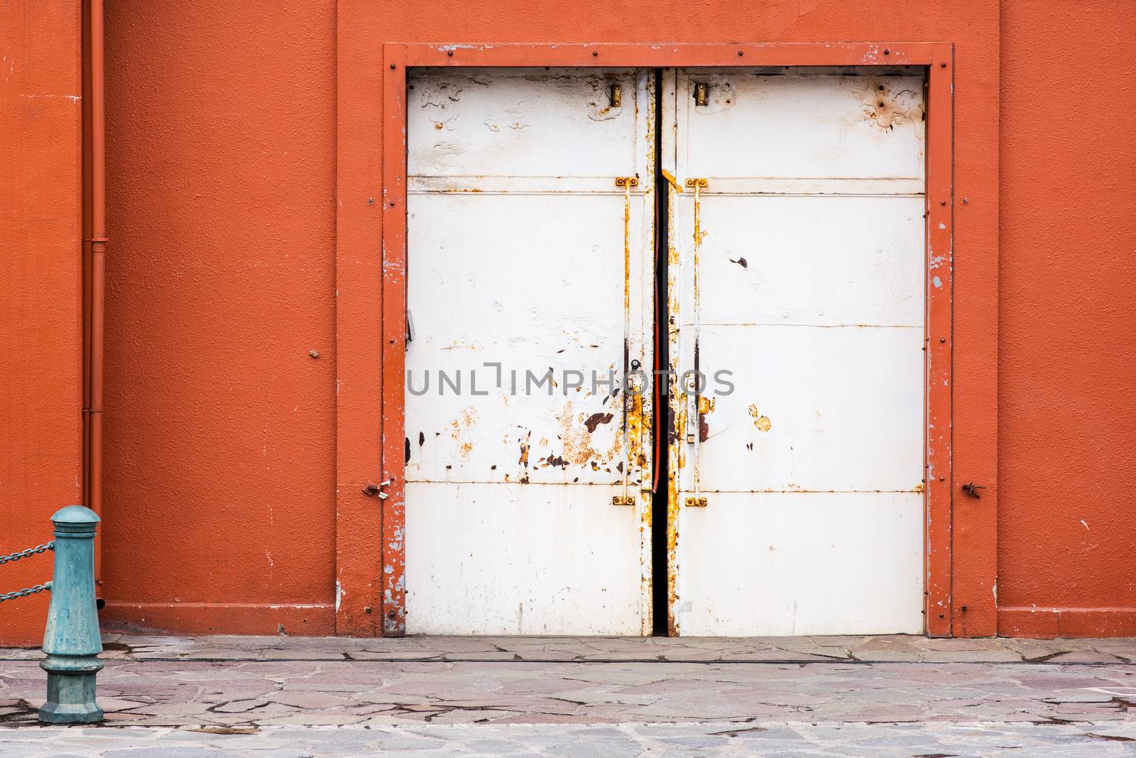 facade of old orange warehouse with white sliding doors