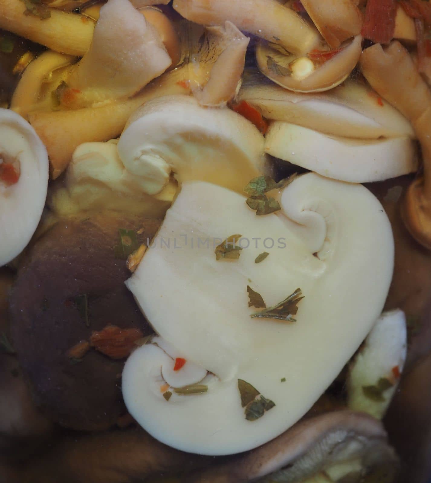 mixed champignons and porcini mushrooms in a glass jar