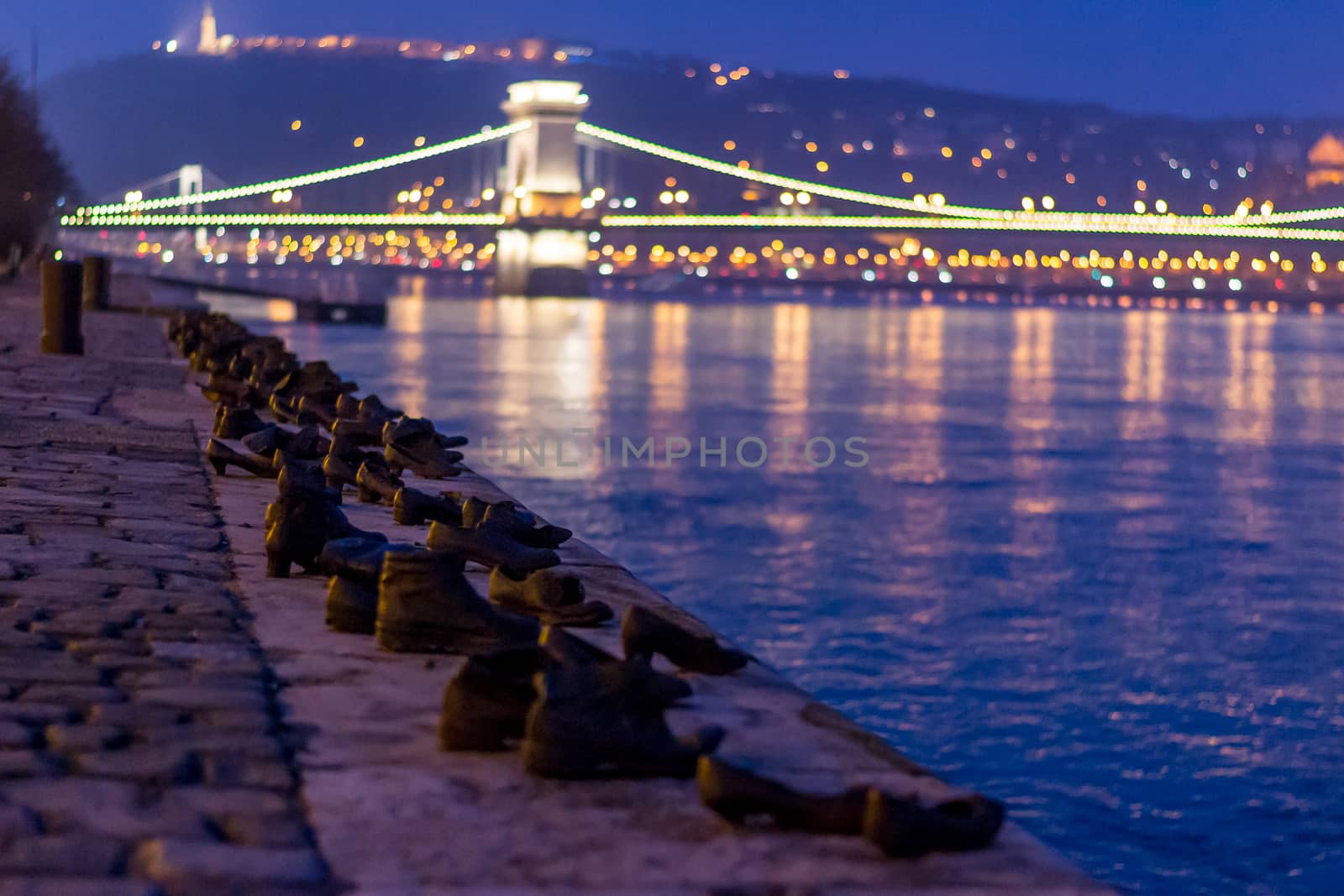 Budapest, Hungary: shoes on the danube monument at night chain bridge and city skyline in the background