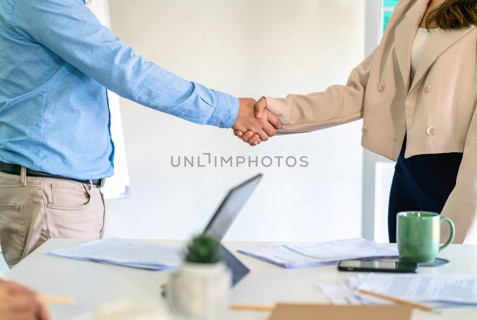 Closeup handshake of asian partner businessman and businesswoman in modern office after deal the agreement together, business Negotiate and accomplishment, Small business owner and stockholder concept