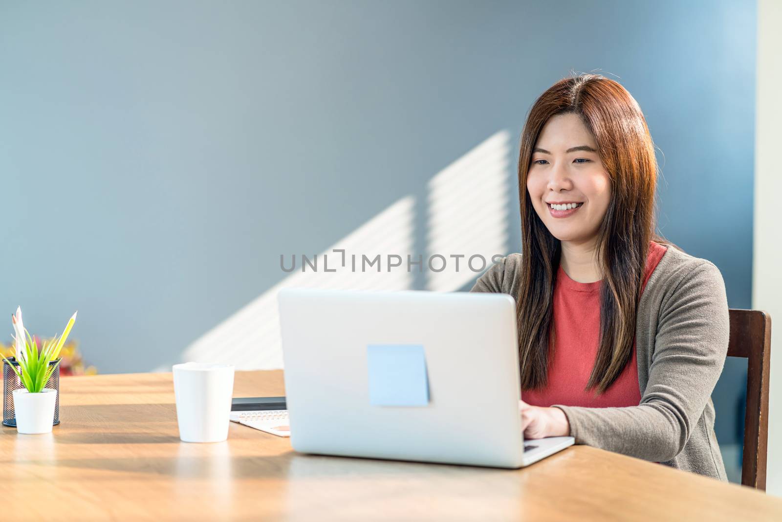 Asian business woman using technology laptop and working from home in indoor modern house, freelance and entrepreneur, creative design and blogger, social distance and self responsibility concept