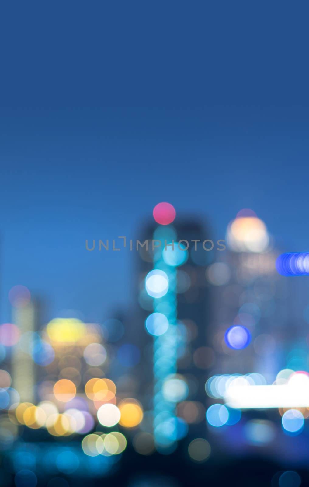 Vertical cover of blurred bokeh cityscape at twilight time, city background, aerial view angle from rooftop ob building, defocused city in downtown,graphic design for web online or book vertical cover