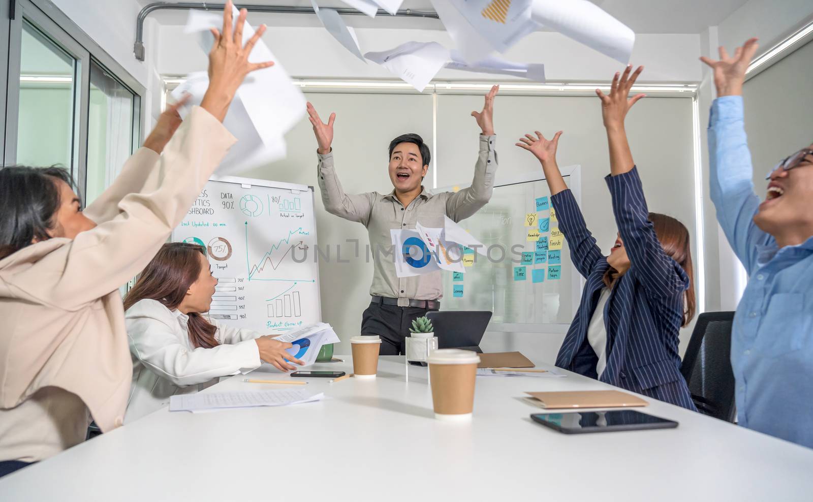 Group Of Asian Business people throwing paper document together with happiness action and celebrating in the modern Office, project succeed and teamwork successful, people business group concept