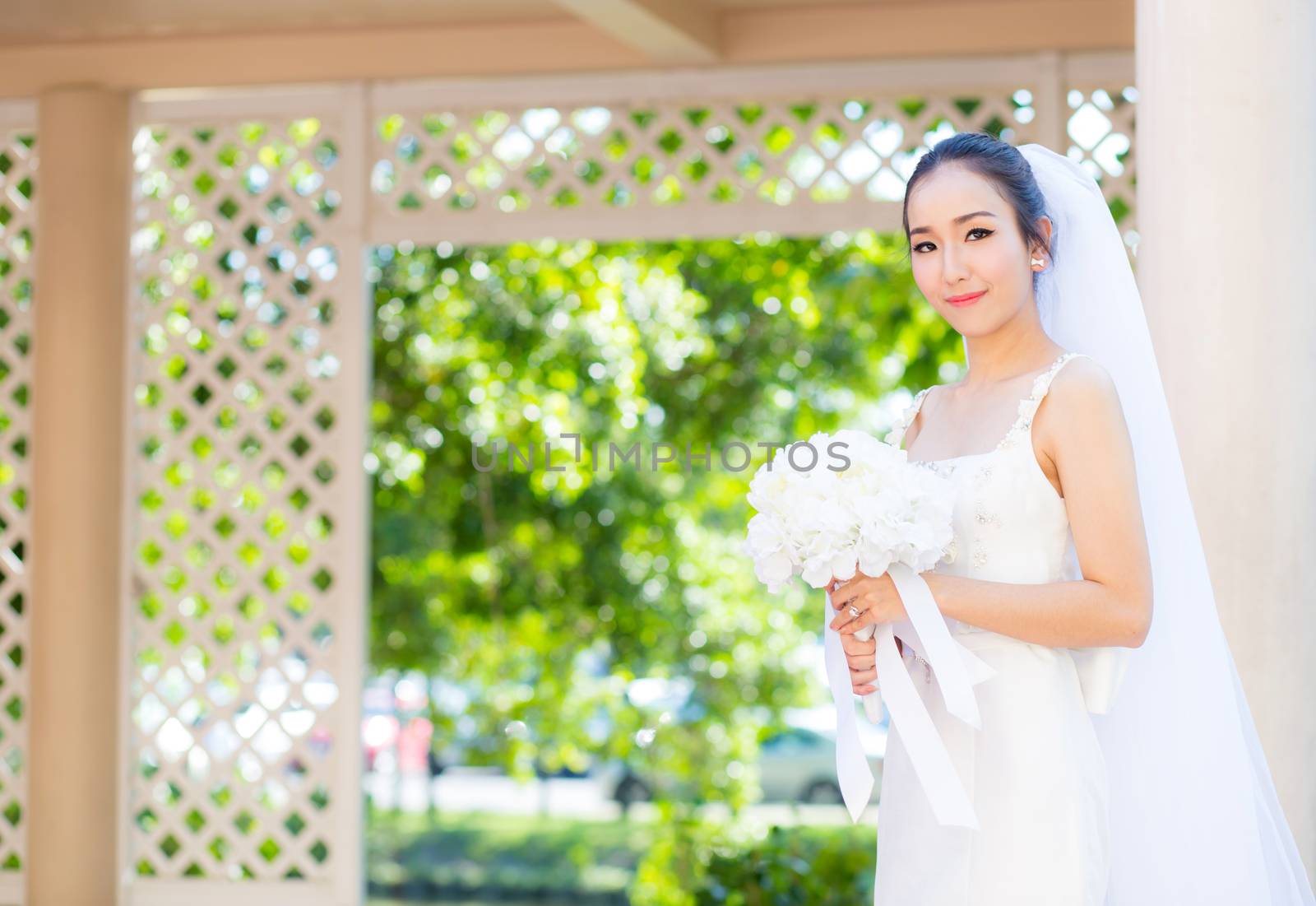 beautiful young woman on wedding day in white dress in the garden. Female portrait in the park.