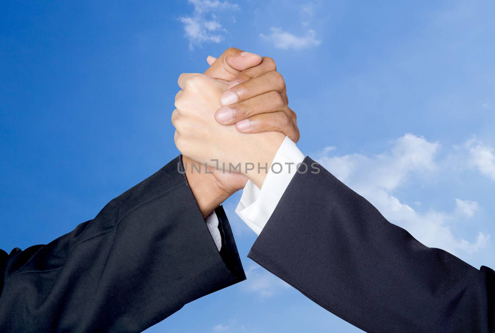 Hand shake between a businessman and a businesswoman sky backgro by nnudoo