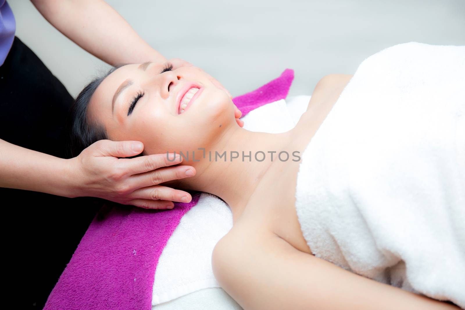 Beautiful woman is getting a facial massage in the spa salon