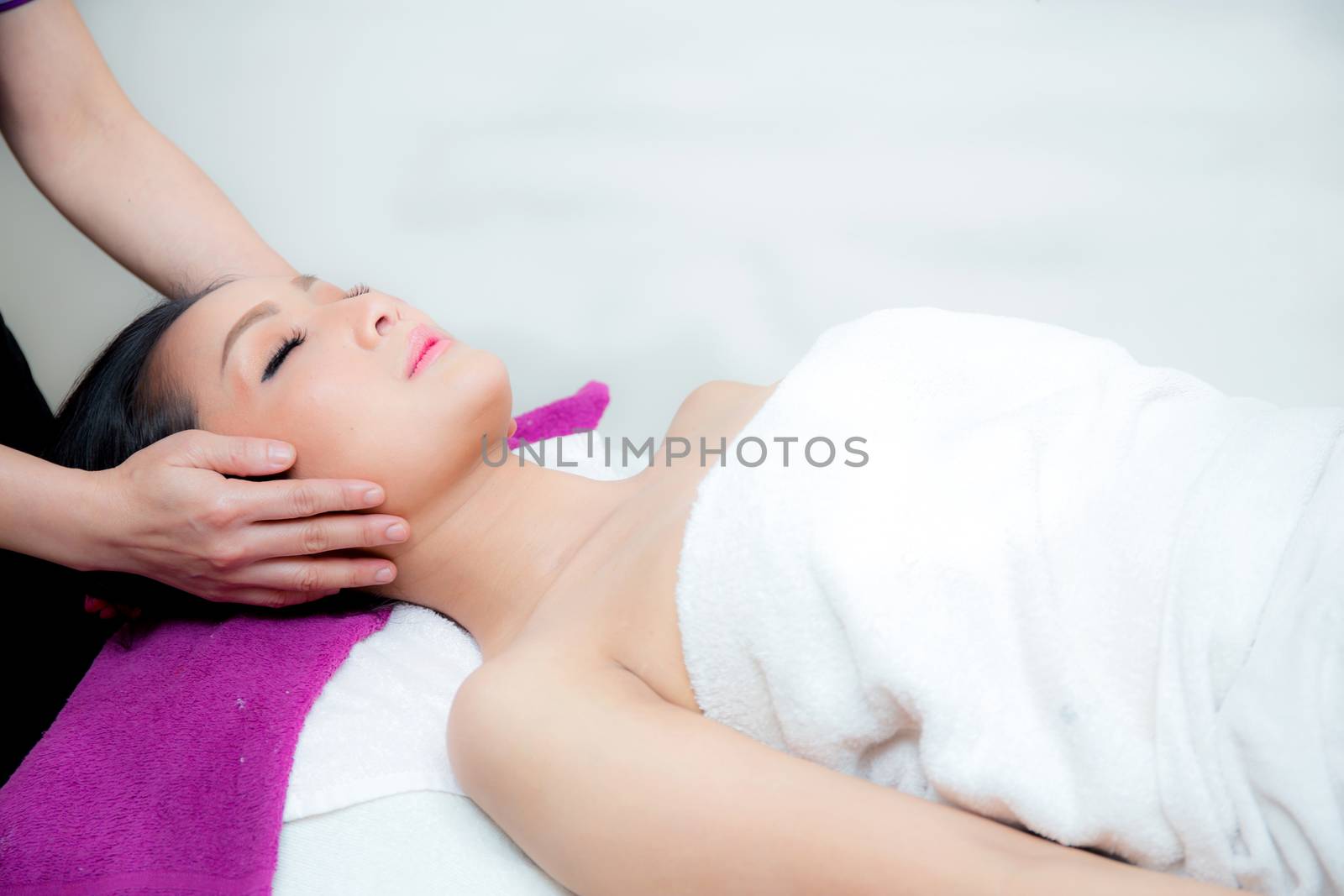 Beautiful woman is getting a facial massage in the spa salon