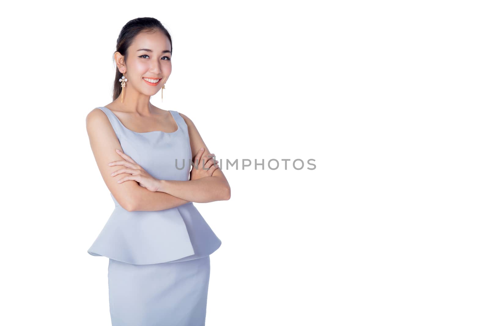 Smiling business woman standing against white background with crossed arms.