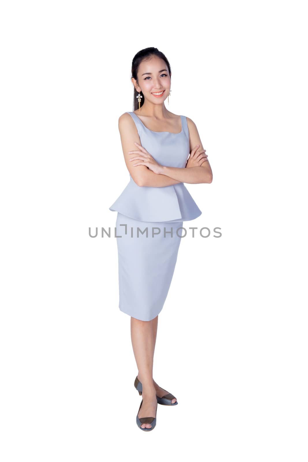 Smiling business woman standing against white background with crossed arms.