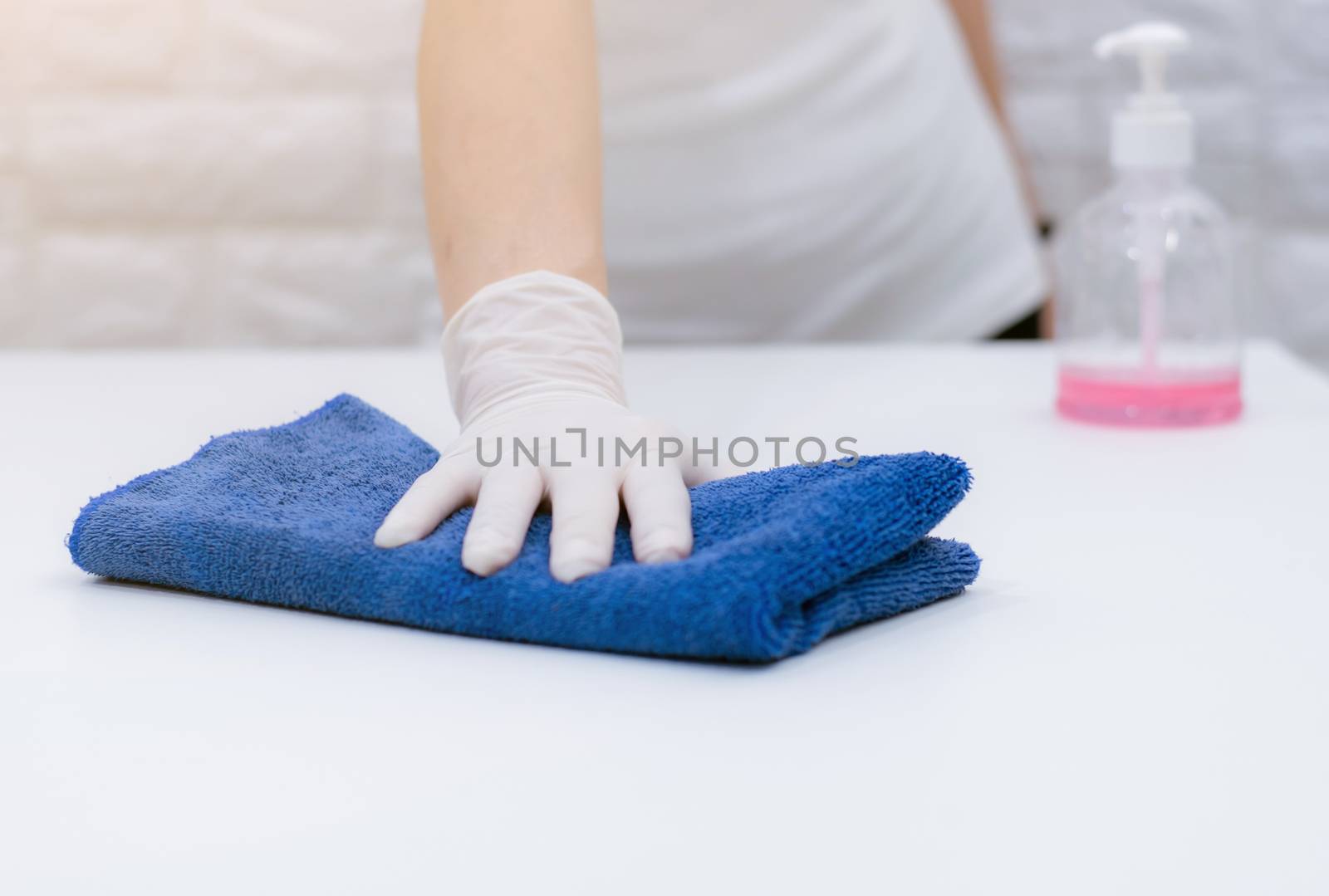 Women wearing gloves to wipe the table to clean the dust by sompongtom