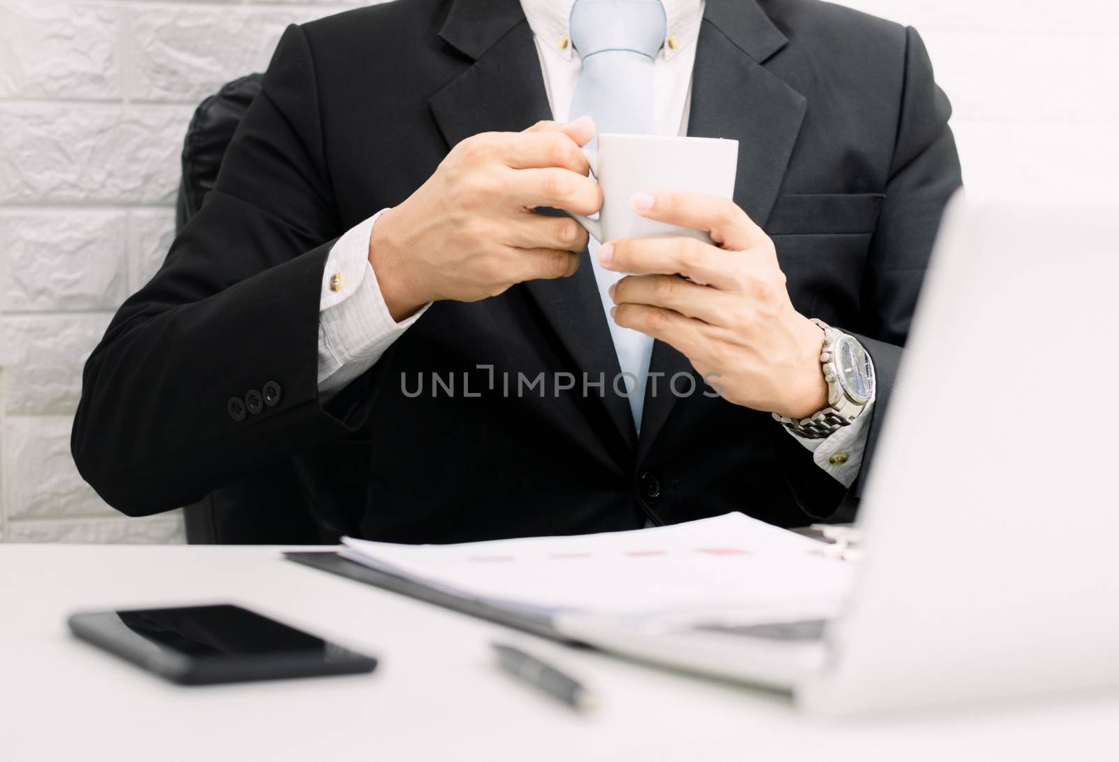 Coffee break businessman executive working relax on laptop at his desk.