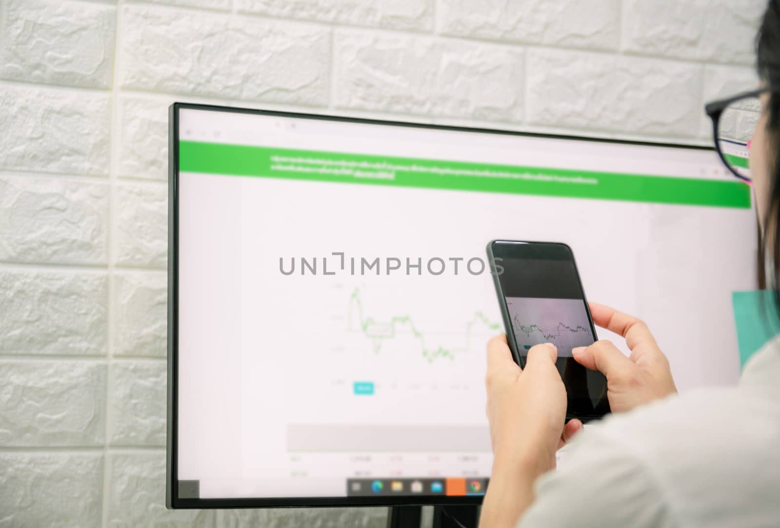 Women working a business on graph analysis with a smartphone