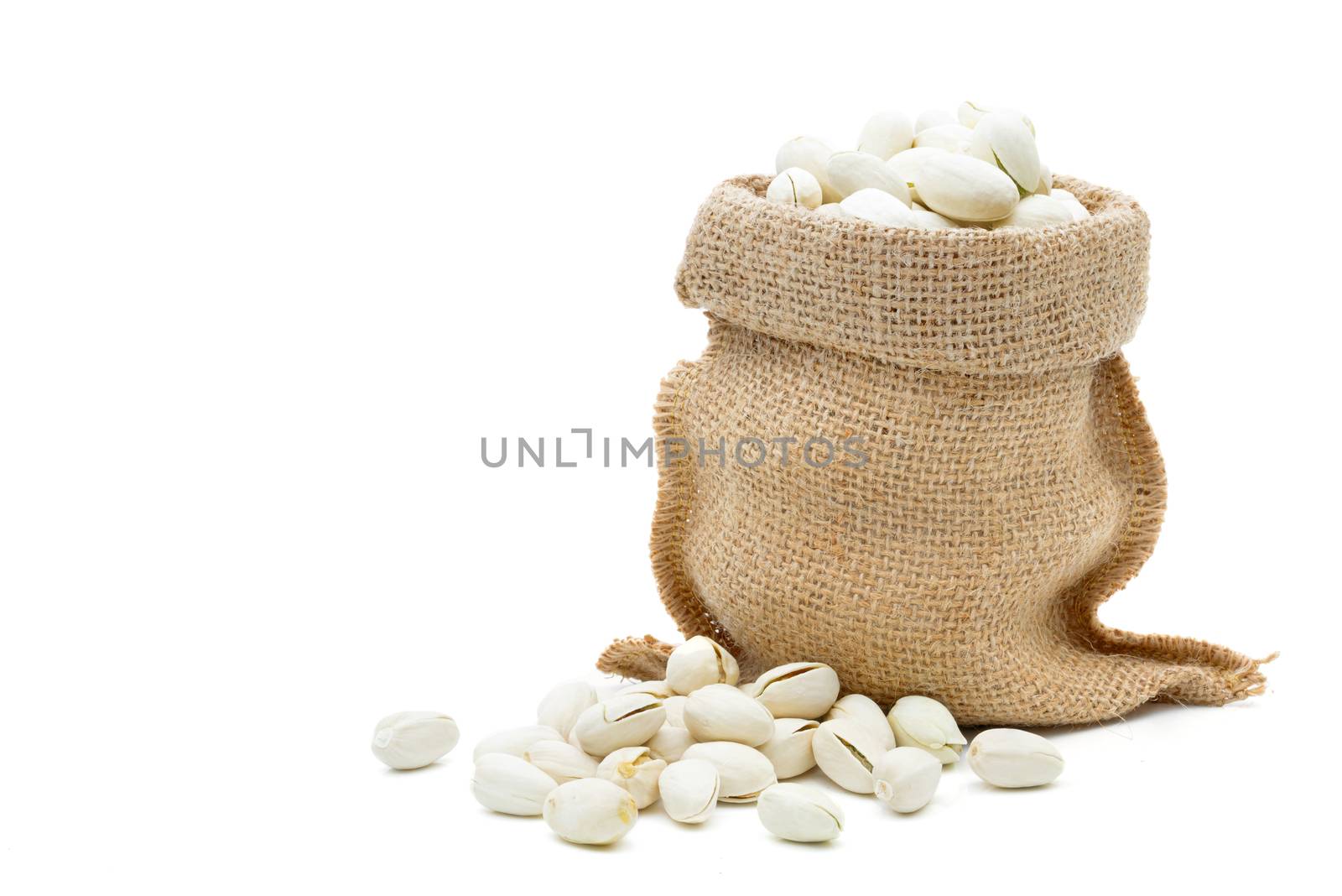 Pistachio in a sack on a white background by sompongtom